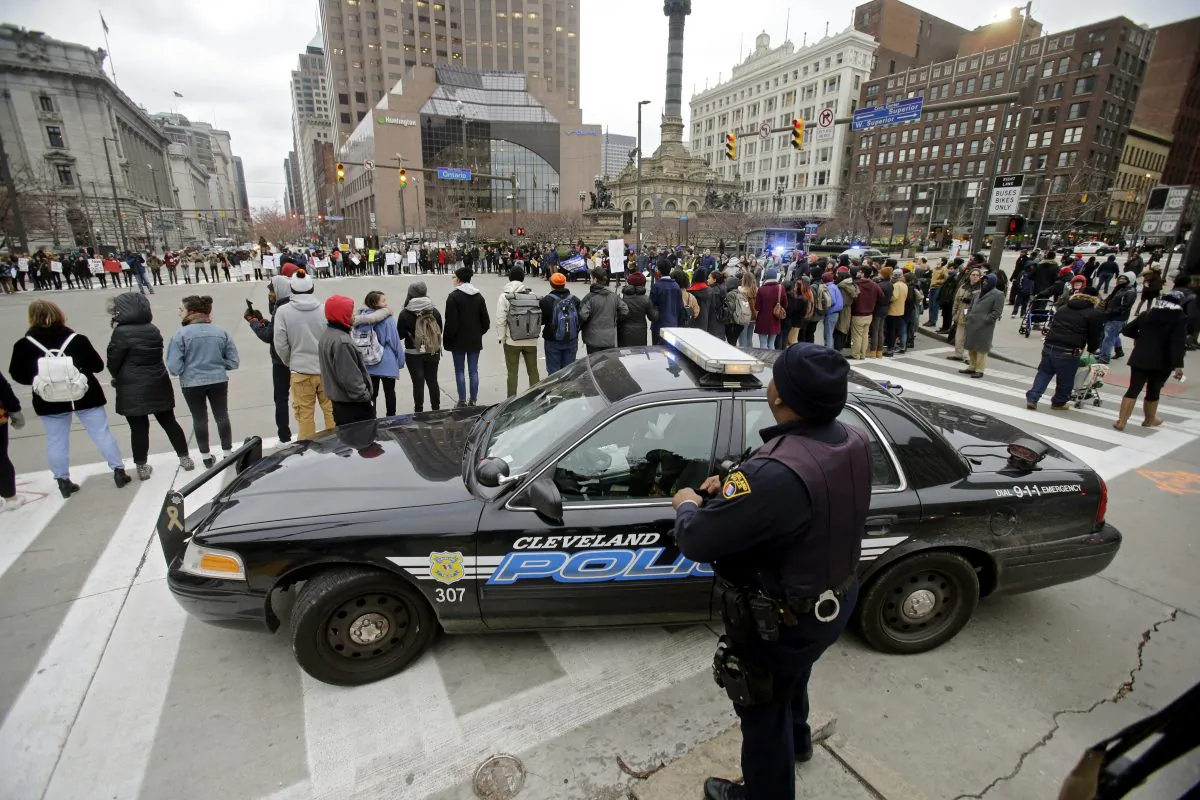Cleveland police watch demonstrators block Public Square iduring a protest over the police shooting of 12-year-old Tamir Rice on Nov. 25, 2014. (AP Photo/Mark Duncan, File)