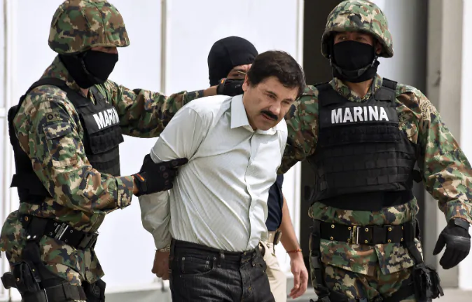 Mexican drug trafficker Joaquin Guzman Loera aka 'el Chapo Guzman' (C), is escorted by marines as he is presented to the press on February 22, 2014 in Mexico City. (RONALDO SCHEMIDT/AFP/Getty Images)