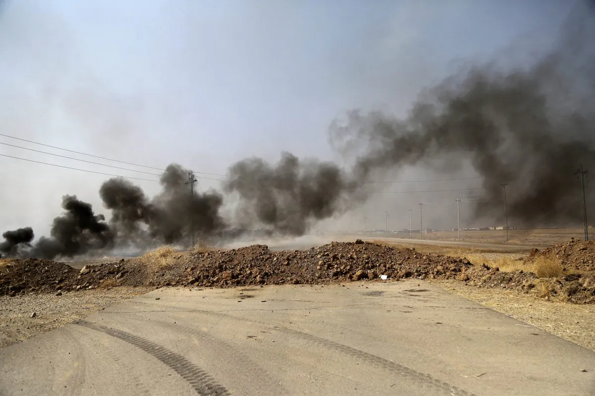 FILE - In this Oct. 17, 2016 file photo, smoke rises from Islamic state positions after an airstrike by coalition forces in villages surrounding Mosul, in Khazer, about 19 miles east of Mosul, Iraq. As the Islamic State group sees its territory shrink to half its original size and its dreams of a caliphate evaporate, the extremist fighters are losing access to the sources of revenue that once gave them their power, prompting them to turn to extortion, kidnapping or foreign donations like their predecessors, the militant group al-Qaida.  (AP Photo, File)