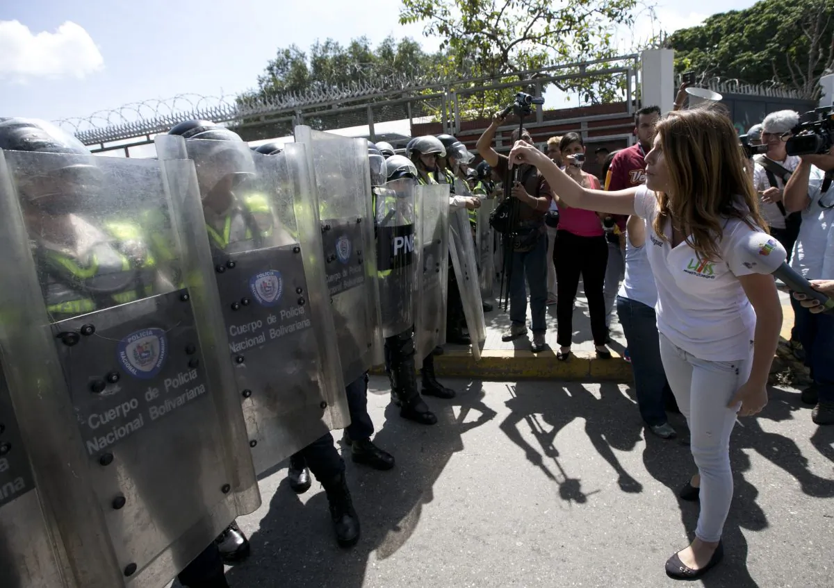A university student confronts police standing guard during a protest demanding a recall referendum against Venezuela's President Nicolas Maduro, near the Central University of Venezuela (UCV) in Caracas, Venezuela, on Oct. 21, 2016. (AP Photo/Ariana Cubillos)