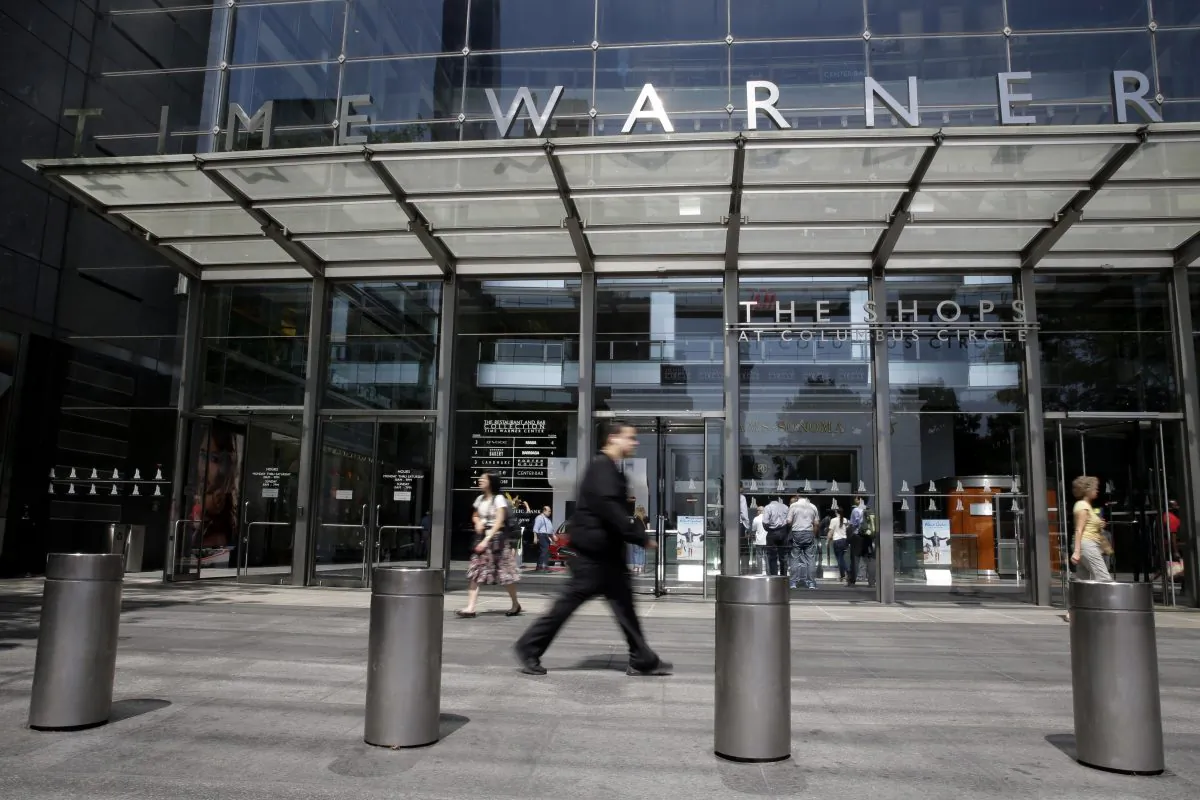 Pedestrians walk by an entrance to the Time Warner Center in New York on May 26, 2015. AT&T announced on Sept. 22 the acquisition of Time Warner for $85 billion in a stock-and-cash deal. (AP Photo/Mary Altaffer)