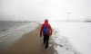 A man walks on the Coney Island beach during a morning snow storm in the Brooklyn borough of New York City on Feb. 22, 2008. (Mario Tama/Getty Images)