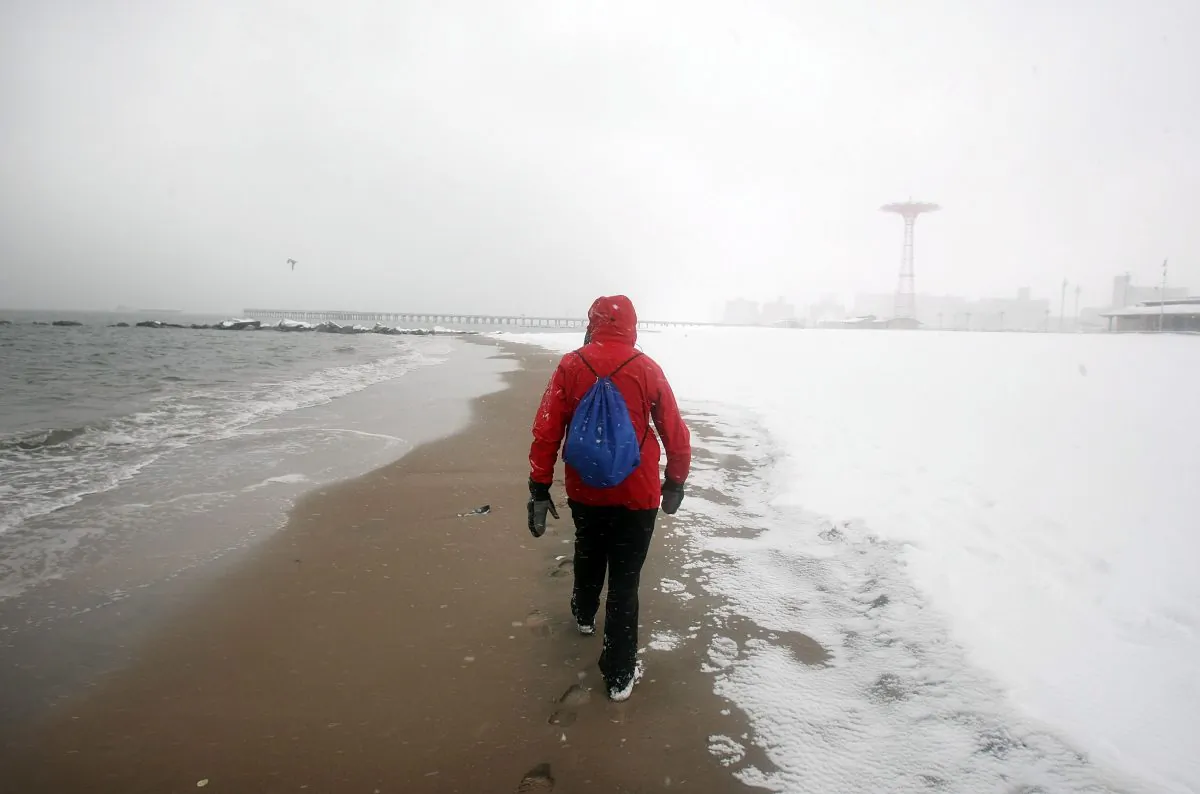 A man walks on the Coney Island beach during a morning snow storm in the Brooklyn borough of New York City on Feb. 22, 2008. (Mario Tama/Getty Images)
