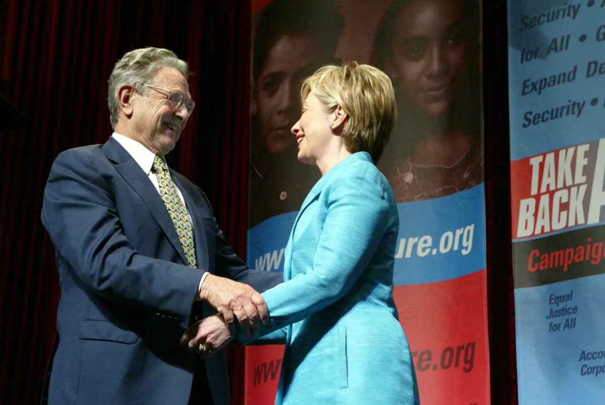 Philanthropist George Soros greets U.S. Senator Hillary Clinton (D-NY) after she introduced him at the Take Back America Conference in Washington on June 3, 2004. (Matthew Cavanaugh/Getty Images)