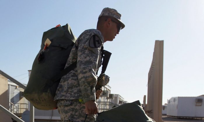 U.S. Army Private First Class soldier from Sacramento, California carries his gear to a staging area as they wait for the orders to convoy to Kuwait from Camp Adder on December 6, 2011 at Camp Adder, near Nasiriyah, Iraq. (Photo by Joe Raedle/Getty Images)