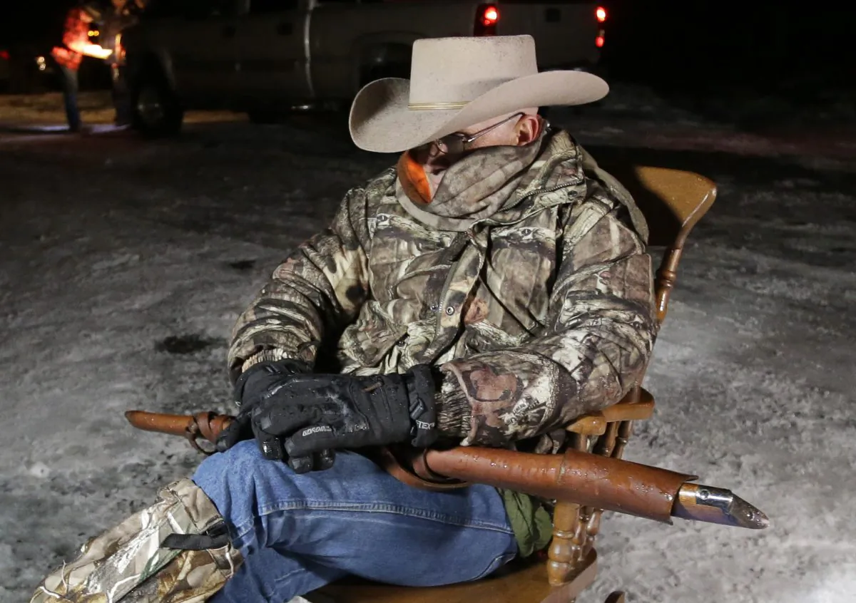 Arizona rancher LaVoy Finicum, holds a rifle as he guards the Malheur National Wildlife Refuge near Burns, Ore., on Jan. 5, 2016. (AP Photo/Rick Bowmer)