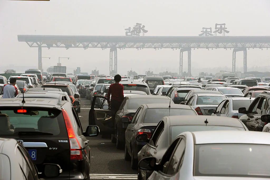 Chinese motorists get out of their cars to check on a massive traffic jam at a toll booth on the outskirts of Beijing on October 2, 2010. (STR/AFP/Getty Images)
