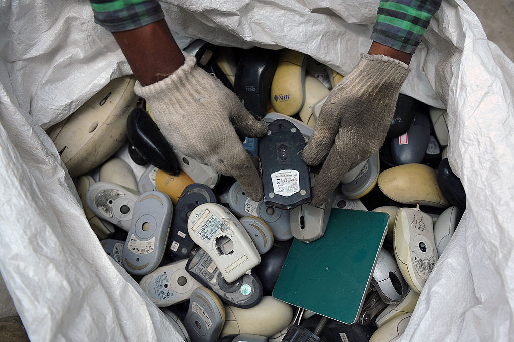 An Indian worker sifts through a bag full of defunct computer mice prior to disassembly at Ash Recyclers, an e-waste management firm in Bangalore on June 5, 2013. (Manjunath Kiran/AFP/Getty Images)