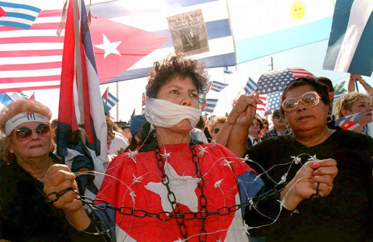 A Cuban woman is symbolically gagged and tied up with chains and barbed wire to protest the regime of Cuban leader Fidel Castro and denounce the lack of freedom of expression in Cuba during a pro-democracy anti-Castro march through the streets of Little Havana in Miami, Fla., on Dec. 10. (Pedro Ugarte/AFP/Getty Images)