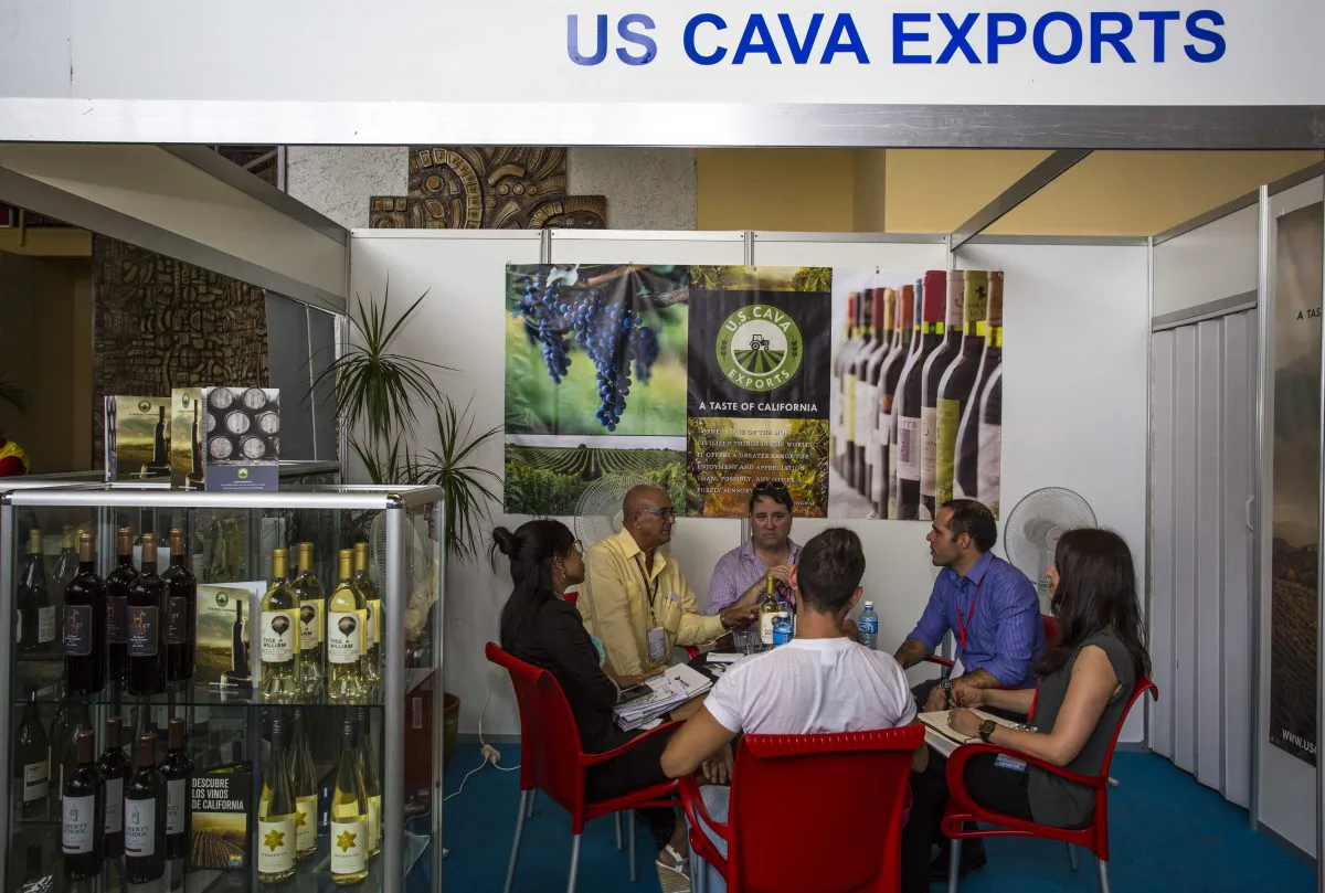People sit at a booth of the United States with wines from California at the 34th Trade Fair in Havana, Cuba, Monday, Oct. 31, 2016. “The Cuban government is using the interest by U.S. companies as bait to entice the interest of companies in other countries,” said John Kavulich of the U.S.-Cuba Trade and Economic Council, a private group that produces mostly skeptical analyses of the prospects of U.S.-Cuba trade. “The Cuban government is saying ‘let’s not give any more than absolutely necessary to U.S. companies so that the companies will continue to salivate toward illusory potential opportunities. There’s far more inspiration and aspiration than reality.” (AP Photo/Desmond Boylan)