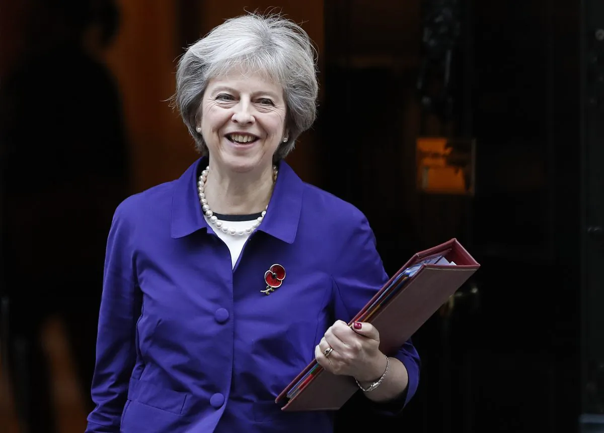 Britain's Prime Minister Theresa May leaves Downing Street to attend the weekly Prime Ministers' Questions session, in parliament in London, Wednesday, Nov. 2, 2016. Theresa May has condemned international soccer organization FIFA for its ban on players wearing the Britain’s remembrance poppy. She told Parliament on Wednesday that the FIFA decision was “utterly outrageous.” (AP Photo/Kirsty Wigglesworth)