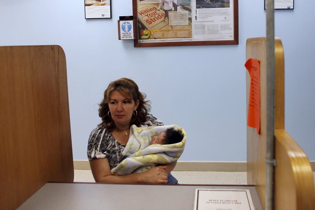 A woman holds her new baby during a visit to the Jessie Trice Community Health Center, Inc. in Hialeah, Fla. on September 23, 2009. (Joe Raedle/Getty Images)