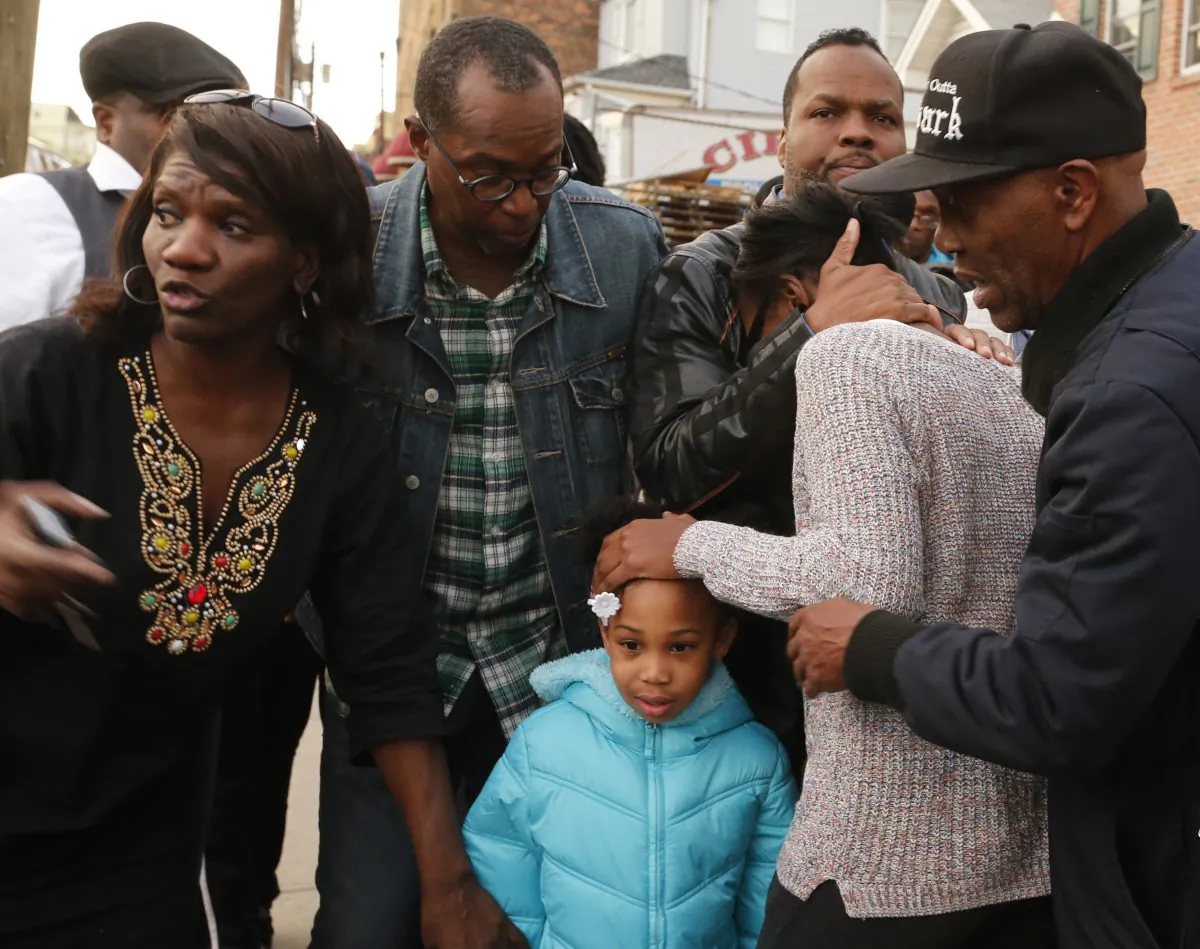 An unidentified women is comforted after learning that three people were killed and several others injured in a stabbing at a house Saturday, Nov. 5, 2016, in Newark N.J. (Robert Sciarrino /NJ Advance Media via AP)
