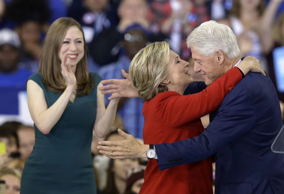 Democratic presidential candidate Hillary Clinton hugs her husband, former President Bill Clinton as their daughter Chelsea Clinton looks on during a campaign rally in Raleigh, N.C., Tuesday, Nov. 8, 2016. (AP Photo/Gerry Broome)