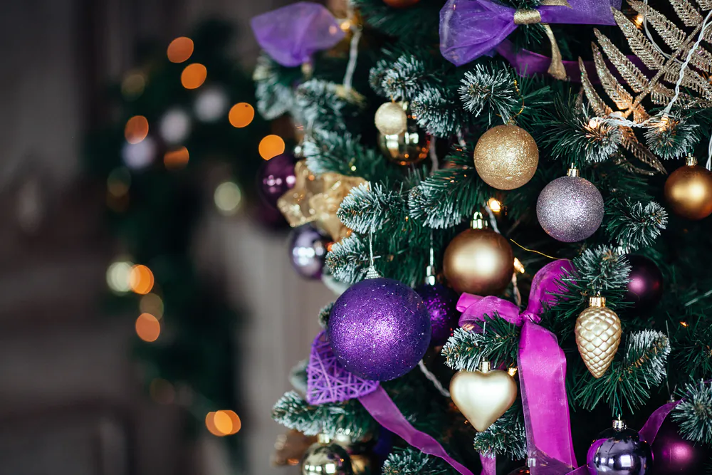 Rich plum- and gold-coloured ornaments decorate this holiday tree.  (tatsmis/Shutterstock) 