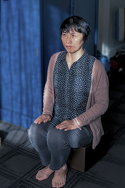 Sunny Guo demonstrates a torture method that was used on her in Chinese force labor camp."You suffer a lot. It makes you feel like one second [is] just like one year," she said about sitting in this fixed position without moving in a child's plastic chair for up to 18 hours with only a few minutes for eating and bathroom. (Cat Rooney/Epoch Times)