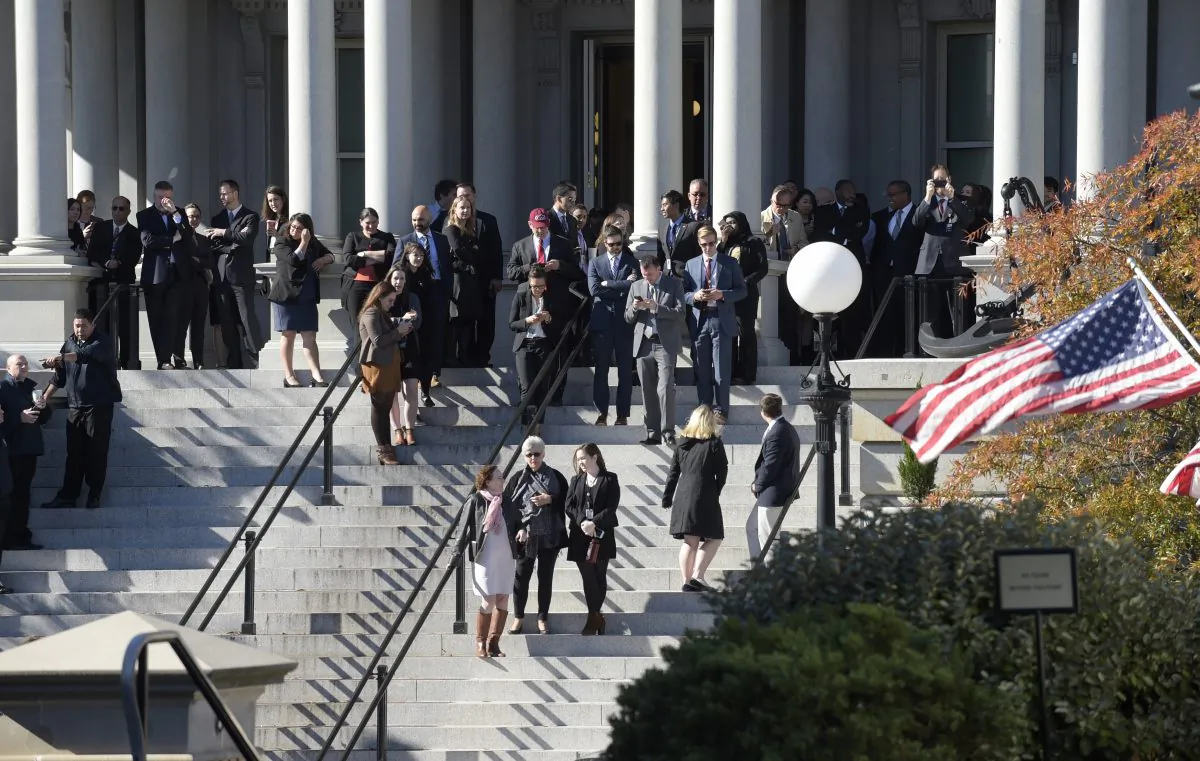 People stand on the steps of the Eisenhower Executive Office Building, next to the White House in Washington on Nov. 10, 2016, as they wait for the arrival of President-elect Donald Trump for his meeting with President Barack Obama. (AP Photo/Susan Walsh)