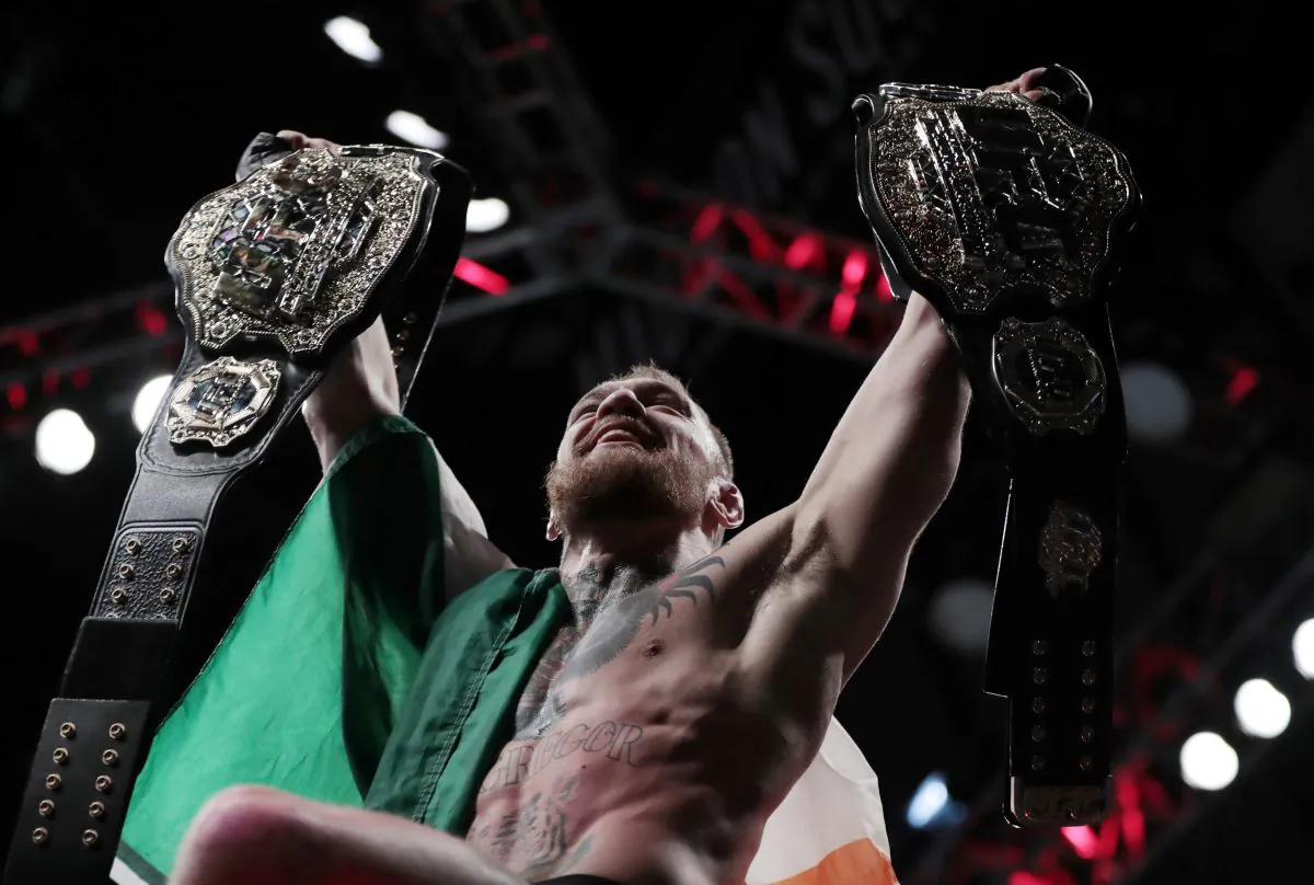 Conor McGregor holds up his title belts after he defeated Eddie Alvarez during a lightweight title mixed martial arts bout at UFC 205 on Nov. 13, 2016, at Madison Square Garden in New York. (AP Photo/Julio Cortez)