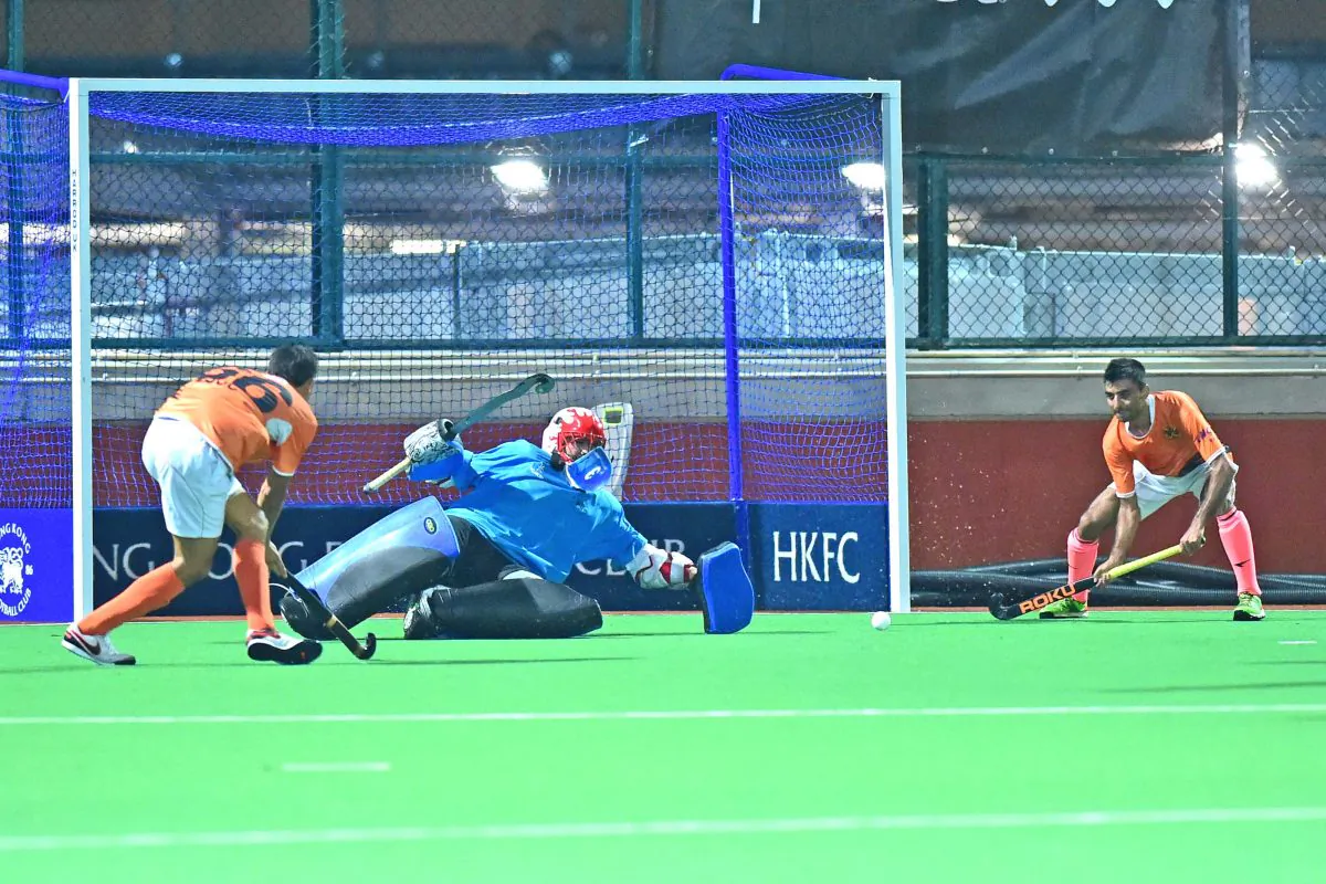SSSC-A’s Amritpal Shing Gill calmly passes the ball across the HKFC-A goalie for his colleague Muhammad Jaffar to slot the ball home for their winning goal in the HKHA Premier Division match at HKFC on Sunday Nov 13. (Bill Cox/Epoch Times)