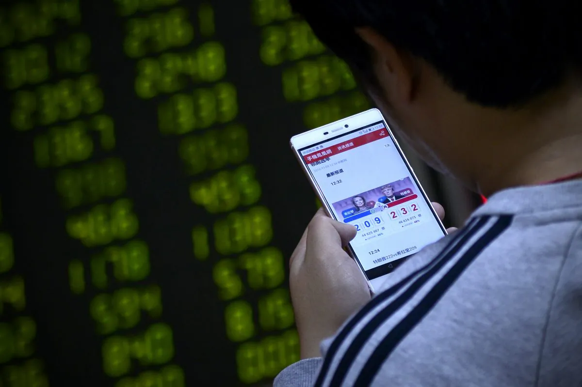 A Chinese investor watches the U.S. presidential election on his smartphone at a securities company in Beijing on Nov. 9. (WANG ZHAO/AFP/Getty Images)