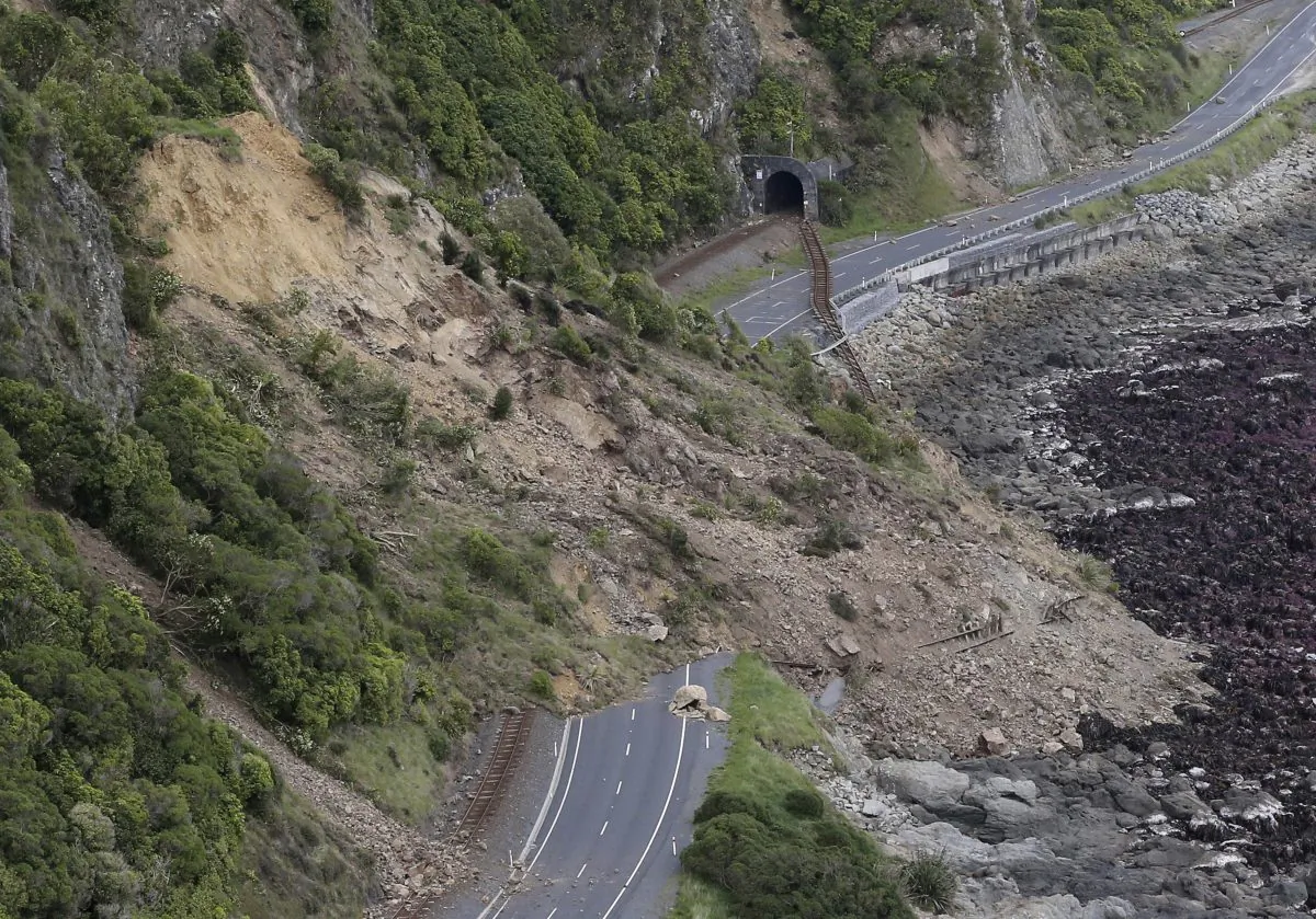 A landslide blocks State Highway One and the main railway line north of Kaikoura following an earthquake in New Zealand, Monday, Nov. 14, 2016. A powerful earthquake that rocked New Zealand on Monday triggered landslides and a small tsunami, cracked apart roads and homes and left two people dead, but largely spared the country the devastation it saw five years ago when a deadly earthquake struck the same region. (Mark Mitchell/New Zealand Herald/Pool via AP)