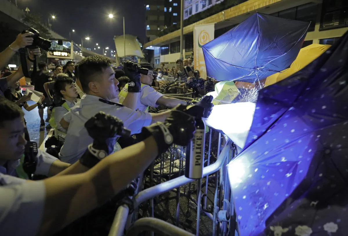 Protesters use umbrellas to block the pepper spray from police officers after clashing outside the Chinese central government's liaison office 
after thousands marched in a parade in Hong Kong on Nov. 6, 2016. 
(AP Photo/Vincent Yu)
