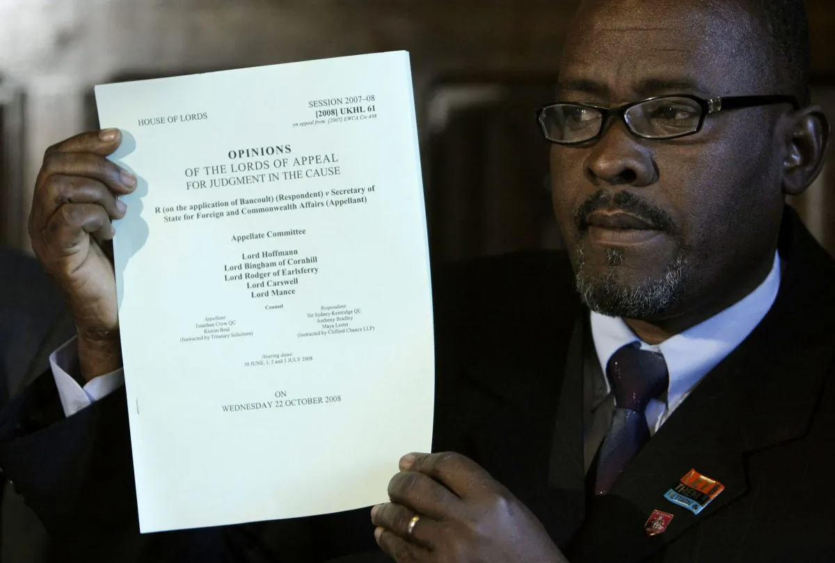 Chagos Islander Olivier Bancoult holds up a judgment paper at the start of a news conference inside the Houses of Parliament in London in this Oct. 22, 2008 file photo. after a court ruling decided Chagos Islanders are not allowed to return to their homeland. Indian Ocean islanders who were forced from their homes decades ago to make way for a U.S. military base will not be allowed to return, the British government has announced. (AP Photo/Matt Dunham, File)