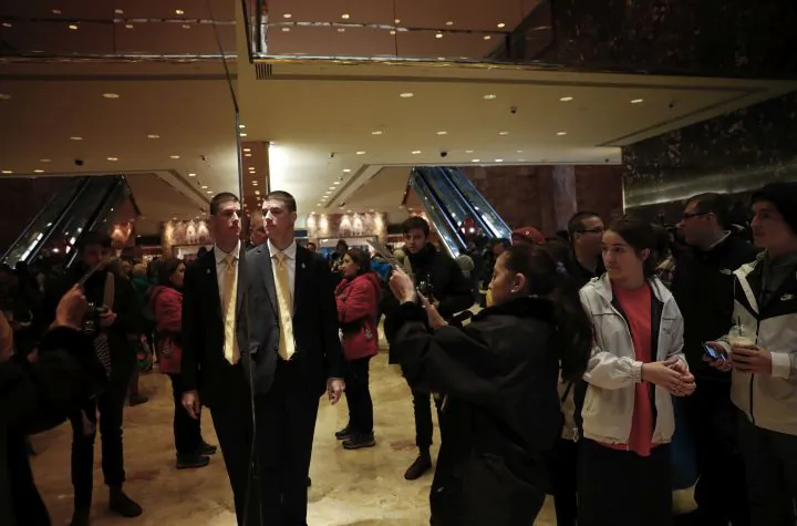Tourists, pedestrians and security gather in the lobby of Trump Tower in New York, Monday, Nov. 21, 2016. Welcome to Trump Tower. Upstairs, the President-elect is planning his administration. Downstairs it’s a full-on political carnival. Since Donald Trump’s stunning presidential victory, the celebrity businessman has largely been ensconced in his penthouse home at his 664-foot glass tower on Manhattan’s Fifth Avenue. But as he works, the political circus that has accompanied his spectacular rise unfolds in the building’s marble-floored, gold-plated public lobby before crowds of journalists, supporters and wide-eyed gawkers.  (AP Photo/Carolyn Kaster)