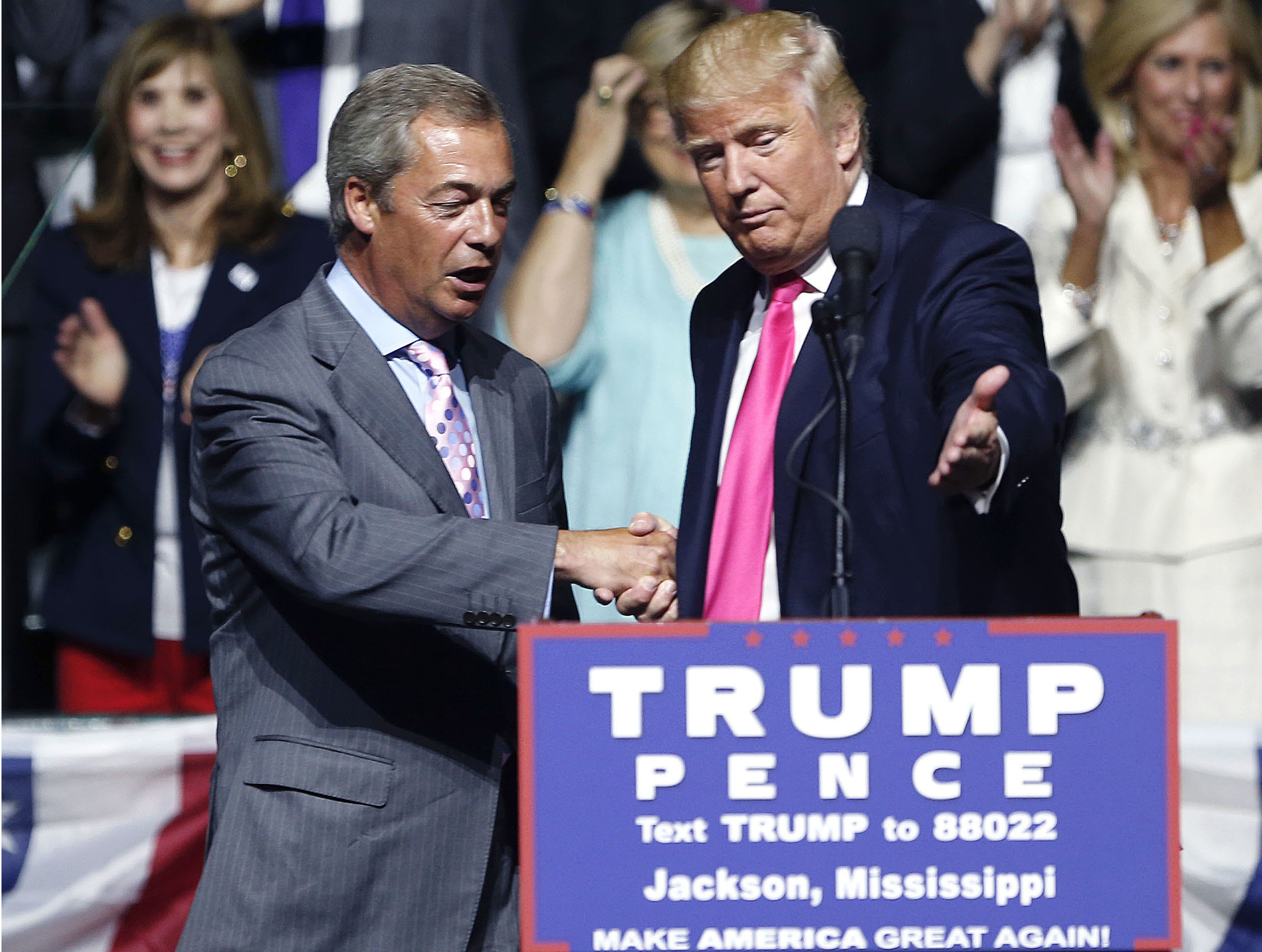 Then-Republican presidential candidate Donald Trump (R) welcomes pro-Brexit British politician Nigel Farage, to speak at a campaign rally in Jackson, Miss., in this file photo. (AP Photo/Gerald Herbert, File)