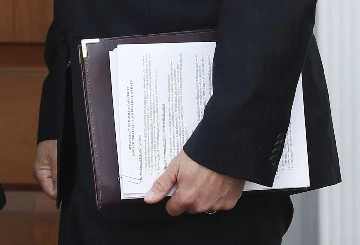 In this Nov. 20, 2016, photo, Kansas Secretary of State Kris Kobach holds a stack of papers as he prepares to meet with President-elect Donald Trump at the Trump National Golf Club Bedminster clubhouse, Sunday, Nov. 20, 2016, in Bedminster, N.J. Kobach, a immigration adviser to rump and a possible candidate for a top government post, wants to make some changes at the Homeland Security Department, including reinstituting a registration system for certain immigrants. Kobach's "Department of Homeland Security Kobach Strategic Plan for First 365 Days" document was visible in a photograph from The Associated Press. (AP Photo/Carolyn Kaster)