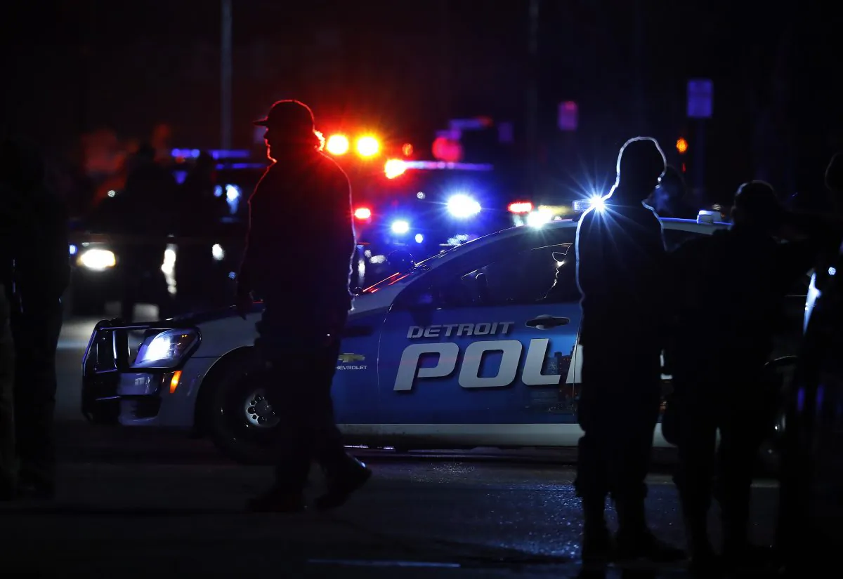 Police search the area where an officer who works for Wayne State University was shot in the head while on duty near the campus in Detroit on Nov. 22, 2016. Authorities said they have a "person of interest" in custody in the investigation into the shooting of the police officer. (AP Photo/Paul Sancya)