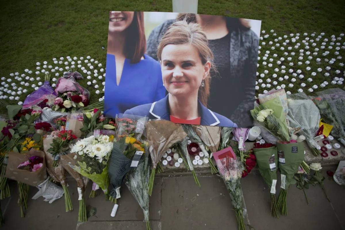 An image and floral tributes for Jo Cox, in Parliament Square, outside the House of Parliament in London, after the 41-year-old British member of Parliament was fatally injured in northern England. (Matt Dunham/AP Photo)