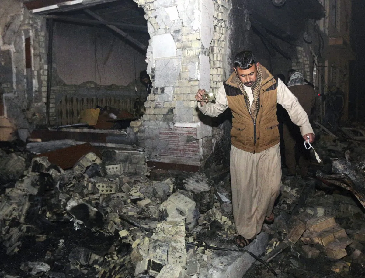 A civilian searches for survivors in the rubble at the scene of a car bomb attack near the city of Hilla on Nov. 24, 2016. (AP Photo/Hadi Mizban)