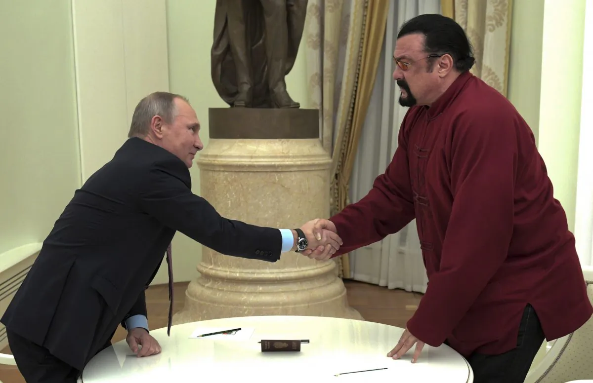 Russian President Vladimir Putin shakes hands with U.S. actor Steven Seagal in the Kremlin in Moscow on Nov. 25, 2016. Putin has given a Russian passport to Seagal, a regular visitor to Russia in recent years, calling it a sign of a thaw in relations between the two countries. (Alexei Druzhinin/Sputnik, Kremlin Pool Photo via AP)