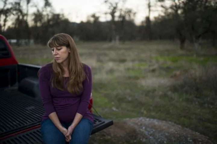 In this Thursday, Nov. 10, 2016 photo, Sheila Koester sits near Sunrise Drive, where her younger sister, Sherri Papini, 34, is believed to have gone missing in Mountain Gate, Calif. The family of the Northern California mother of two who went missing while jogging is holding out hope she will be found alive. The Sacramento Bee reports Saturday that Papini has been missing since she went for a jog Nov. 2, in the tiny town of Mountain Gate in Shasta County. (Andrew Seng/The Sacramento Bee via AP)