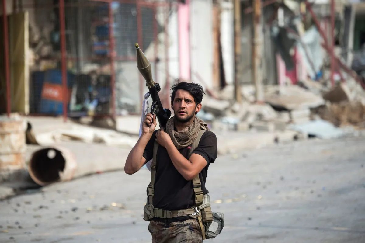 A soldier of the Iraqi special forces carries a rocket propelled grenade as he prepares for a suicide bomb vehicle that was reported to be moving toward their position in Mosul, Iraq, on Nov. 14. (ODD ANDERSEN/AFP/Getty Images)