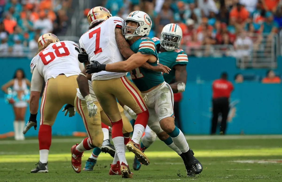 Kiko Alonso #47 of the Miami Dolphins hits Colin Kaepernick #7 of the San Francisco 49ers after a pass during a game in Miami Gardens, Florida on Nov. 27, 2016. (Mike Ehrmann/Getty Images)