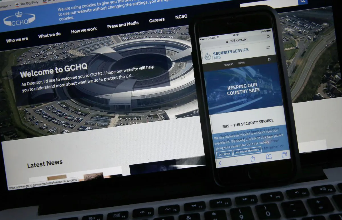 Photo-illustration of web flash pages for GCHQ, the British government's communications and electronic surveillance headquarters, and The Security Service (MI5), the governments internal security service, on a computer and smartphone in London, on Nov. 25, 2016. (AP Photo/Alastair Grant)