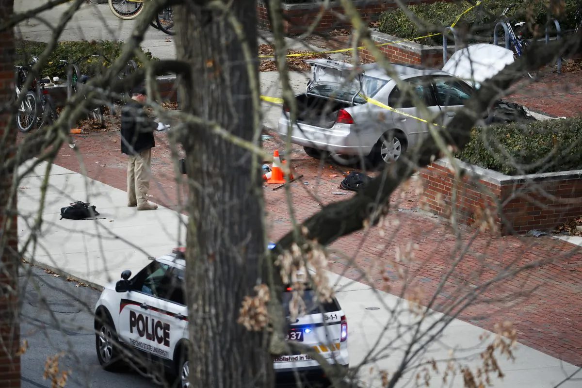 A car inside a police line sits on the sidewalk as authorities respond to an attack on campus at Ohio State University on Nov. 28, 2016, in Columbus, Ohio. Several were injured after a man plowed his car into a group of pedestrians at the university and began stabbing people with a butcher knife Monday before he was shot to death by a police officer. ﻿(AP Photo/John Minchillo)