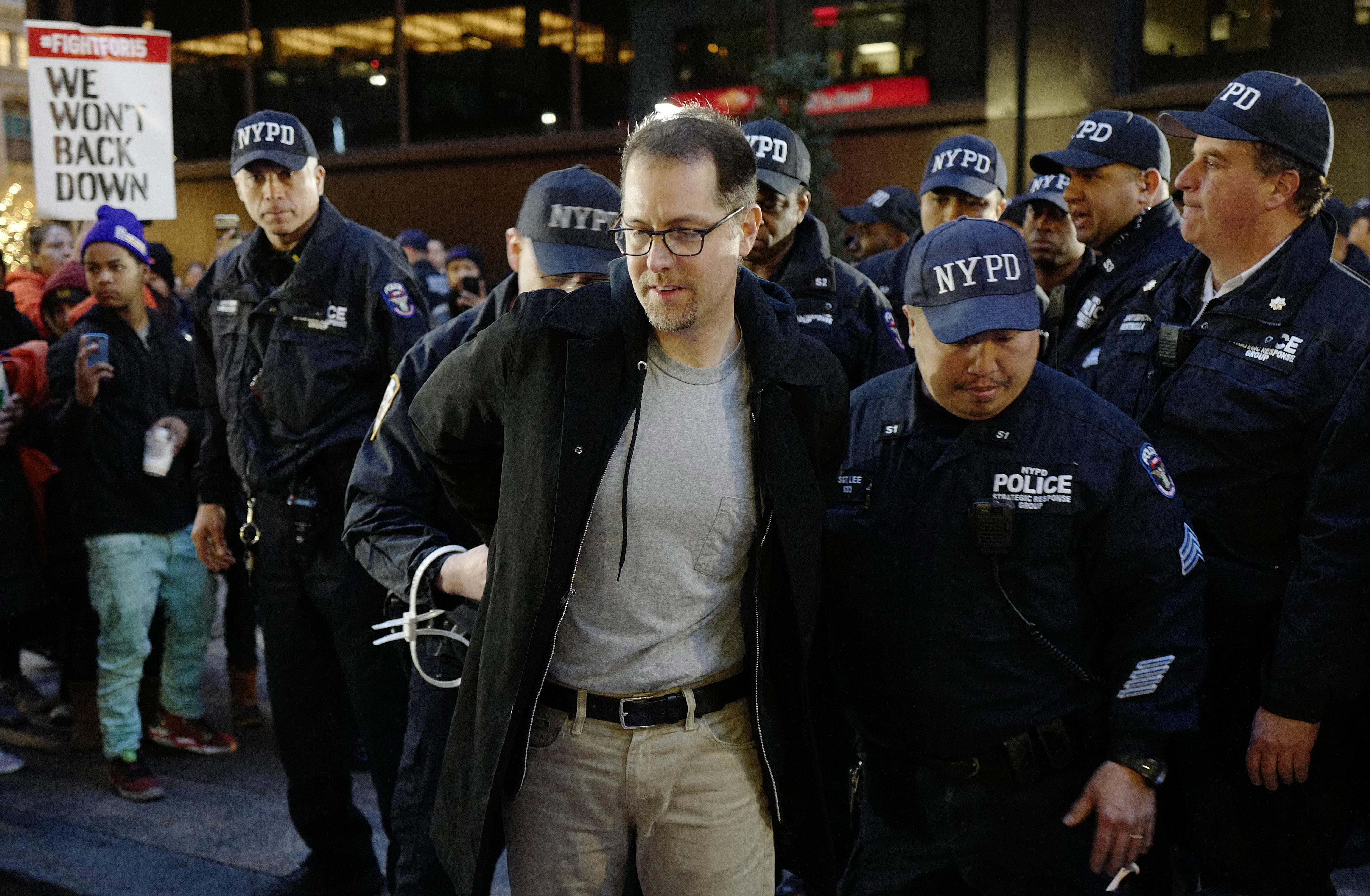 A man is arrested by police officers after he and other protesters blocked Broadway in front of a McDonald's restaurant in New York on Nov. 29, 2016. (AP Photo/Mark Lennihan)