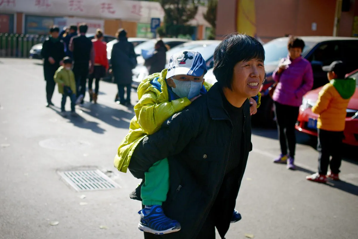 A woman carries a child on her back in Beijing on Nov. 24, 2014. (Wang Zhao/AFP/Getty Images)