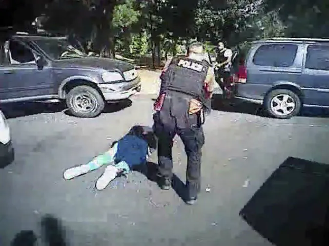 Keith Scott on the ground as police approach him in Charlotte, N.C., on Sept. 20, 2016. (Charlotte-Mecklenburg Police Department via AP)