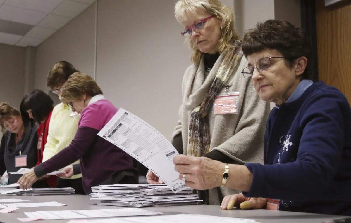 Tabulator Claudette Moll (R) from Farmington, looks over a ballot during a statewide presidential election recount West Bend, Wis., on Dec. 1, 2016. (John Ehlke/West Bend Daily News via AP)