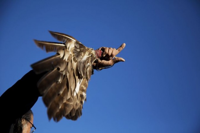 David Swallow, an Oglala Native American, holds an eagle fan as he speaks during an interfaith ceremony at the Oceti Sakowin camp where people have gathered to protest the Dakota Access oil pipeline in Cannon Ball, N.D., Sunday, Dec. 4, 2016. Tribal elders have asked the military veterans joining the large Dakota Access pipeline protest encampment not to have confrontations with law enforcement officials, an organizer with Veterans Stand for Standing Rock said Sunday, adding the group is there to help out those who've dug in against the four-state, $3.8 billion project. (AP Photo/David Goldman)