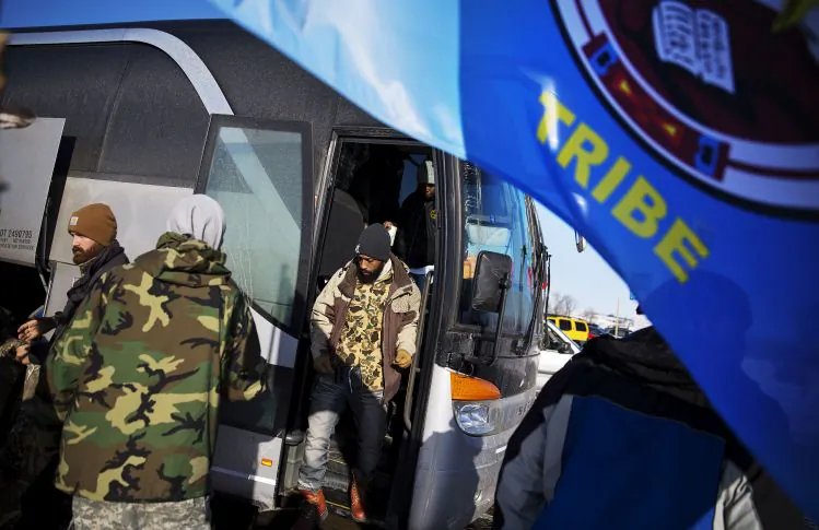 Veterans get off a bus from South Dakota after arriving at the Oceti Sakowin camp where people have gathered to protest the Dakota Access oil pipeline in Cannon Ball, N.D., Sunday, Dec. 4, 2016. Tribal elders have asked the military veterans joining the large Dakota Access pipeline protest encampment not to have confrontations with law enforcement officials, an organizer with Veterans Stand for Standing Rock said Sunday, adding the group is there to help out those who've dug in against the four-state, $3.8 billion project. (AP Photo/David Goldman)