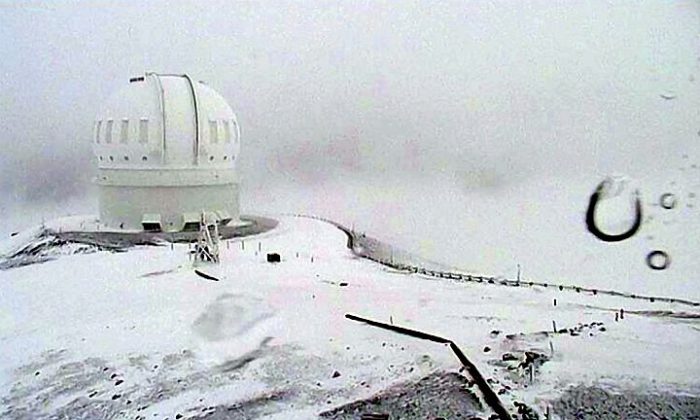 In this image made from webcam video provided by Canada-France-Hawaii Telescope, the CFHT telescope on the summit of Mauna Kea on Hawaii's Big Island is covered in snow on Thursday, Dec. 1, 2016. The National Weather Service in Honolulu has issued a winter storm warning for the summits of Hawaii's Big Island as wind and snow engulf the high peaks. (Canada-France-Hawaii Telescope via AP)