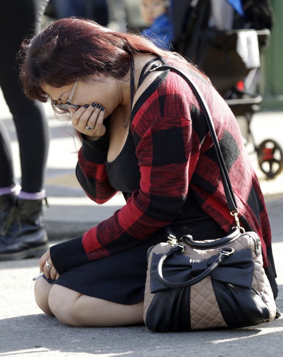 A woman, wishing to not be identified, cries at the scene of a warehouse fire, in Oakland, Calif, on Dec. 4, 2016. (AP Photo/Marcio Jose Sanchez)