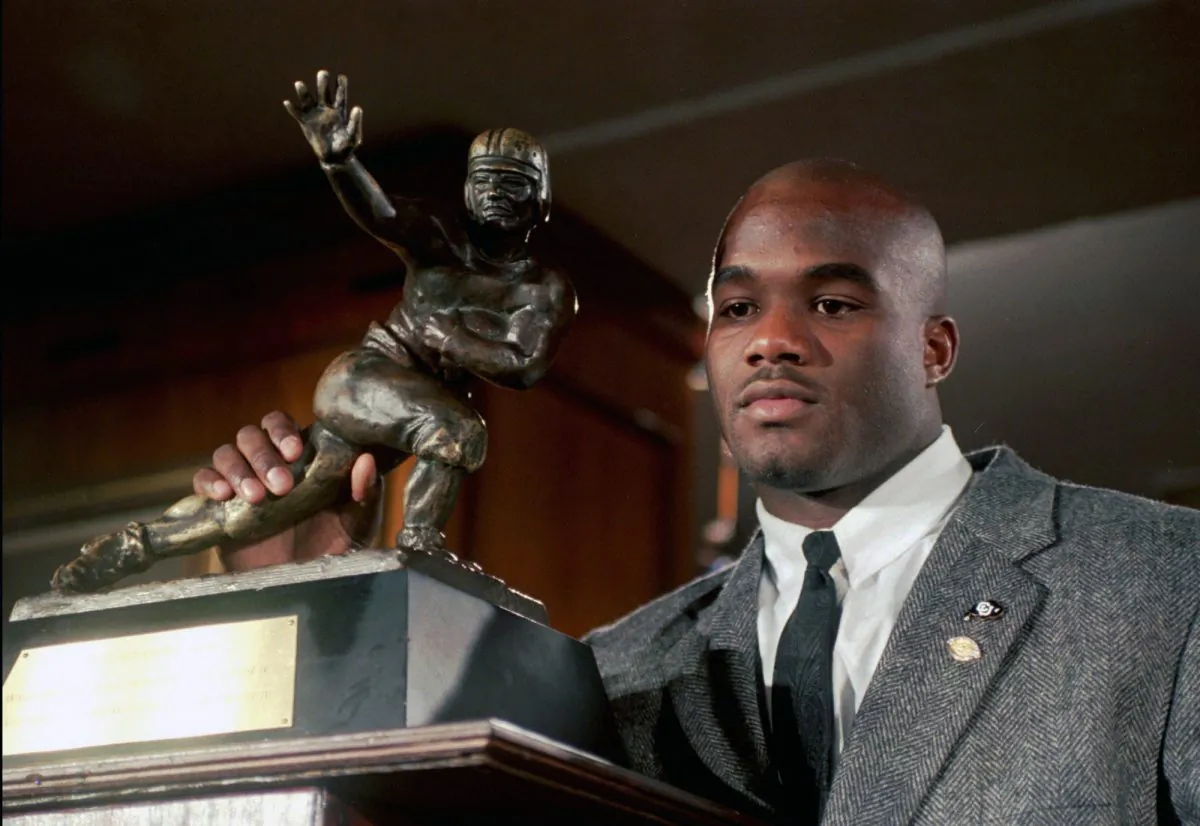 Colorado's Rashaan Salaam poses with his 1994 Heisman Trophy at the Downtown Athletic Club in New York in this Dec. 10, 1994, file photo. Authorities say Rashaan Salaam has been found dead in a park in Boulder, Colo. The Boulder County coroner’s office said on Dec. 6, 2016, that it is still investigating the death of 42-year-old Salaam. (AP Photo/Adam Nadel, File)