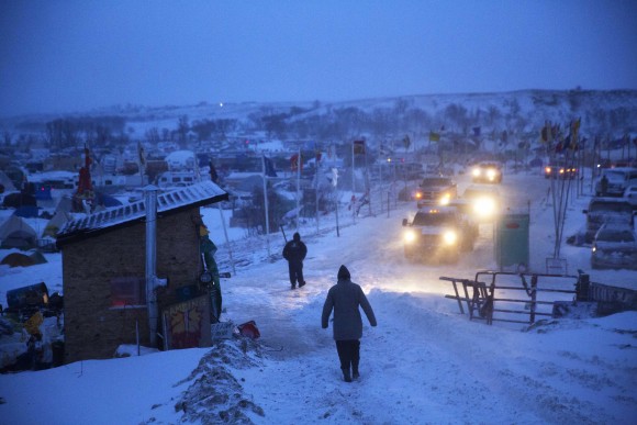A motorist checks the condition of an exit ramp before attempting to drive out of the Oceti Sakowin camp where people have gathered to protest the Dakota Access oil pipeline in Cannon Ball, N.D. on Dec. 6, 2016. An overnight storm brought several inches of snow, winds gusting to 50 mph and temperatures that felt as cold as 10 degrees below zero. (AP Photo/David Goldman)