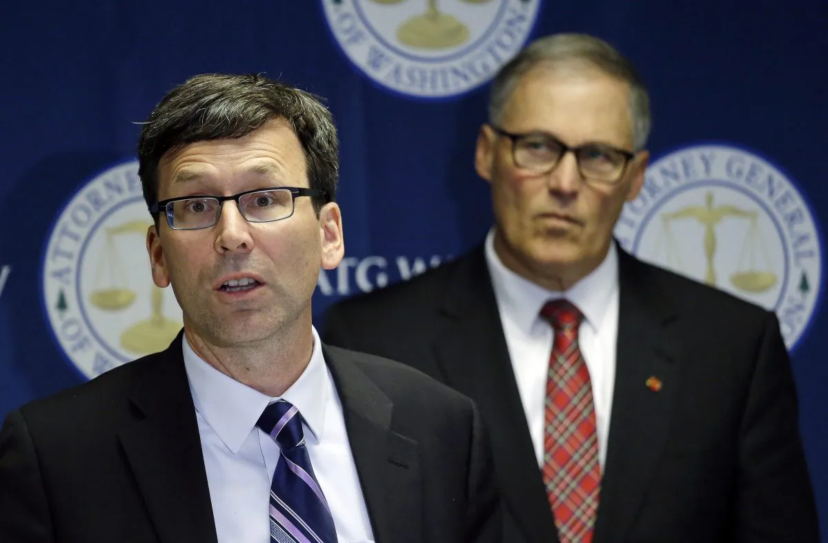 Washington Attorney General Bob Ferguson, left, speaks as Gov. Jay Inslee looks on during a news conference where Ferguson announced a lawsuit against agrochemical giant Monsanto over pollution from PCBs, on Dec. 8, 2016, in Seattle, Washington.